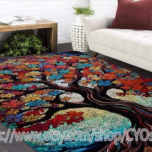 Puede incluir: Una alfombra colorida con un diseño de árbol grande. El árbol tiene un tronco marrón oscuro y ramas con hojas coloridas. El fondo es un mosaico de azul, verde y blanco.