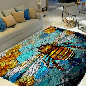 May include: A colorful rug with a stained glass design featuring a bee with yellow and brown stripes, surrounded by blue, green, and orange flowers. The rug has a honeycomb pattern in the background.