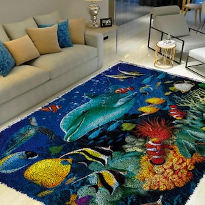 May include: A blue and green rug with a colourful underwater scene. The rug features a dolphin, fish, coral, and seaweed.