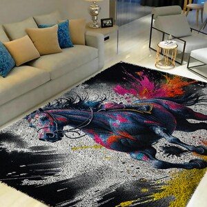 May include: Black and white rug with a colorful abstract design of a horse running. The horse is painted in shades of blue, pink, and yellow.