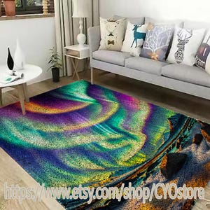 May include: A colorful abstract rug with a swirling pattern of green, blue, purple, and yellow. The rug is laid out on a hardwood floor in a living room setting.