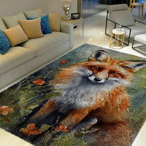 Puede incluir: Una alfombra colorida con una ilustración detallada de un zorro en un entorno de bosque. El zorro está representado en tonos de naranja, marrón y blanco, con un exuberante fondo verde.