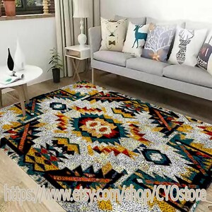 Könnte beinhalten: Ein farbenfroher geometrischer Teppich mit weißem Hintergrund und schwarzen, roten, gelben und blauen Akzenten. Der Teppich hat ein tribales Muster und ist perfekt, um jedem Raum einen Hauch von Boho-Stil zu verleihen.