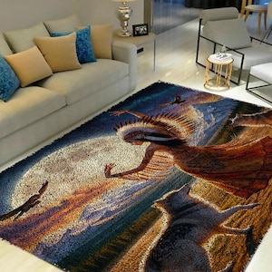 May include: A colorful rug with a Native American woman in a feathered headdress dancing with wolves. The rug has a blue, brown, and gold color scheme and features a large moon in the background.