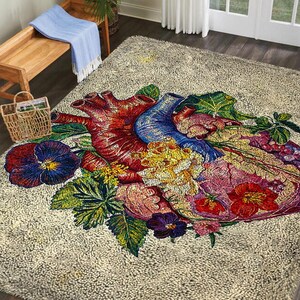 May include: A beige area rug featuring a detailed, colorful illustration of a human heart surrounded by flowers and foliage. The heart is depicted in shades of red, blue, and purple, with yellow and pink floral accents. The rug has a textured surface.
