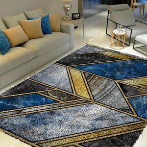 May include: A geometric patterned rug with blue, gold, and gray colors. The rug has a modern design with a marble-like texture.