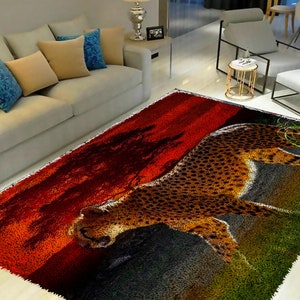 May include: A colorful rug with a cheetah print design. The rug features a red, orange, and yellow sunset background with a green and brown grassy foreground. The cheetah is walking across the rug, with its head turned to the side.