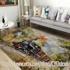 May include: A watercolor-style rug featuring a vintage steam train traveling through a forest landscape. The rug has a light brown background with green and orange accents. The train is black with red accents and is surrounded by trees and foliage.