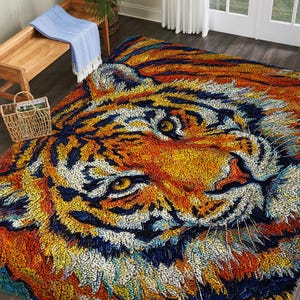 May include: A large, colorful rug featuring a detailed tiger face design. The rug showcases a vibrant palette of orange, yellow, blue, and white, creating a striking visual impact. The rug is placed on a dark wood floor, adding warmth to the room.