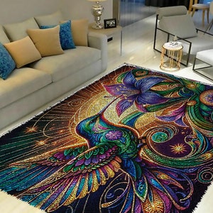 May include: A colorful rug with a hummingbird and a flower design. The hummingbird is green, blue, purple, and gold. The flower is purple and blue. The background is black with gold and silver accents.
