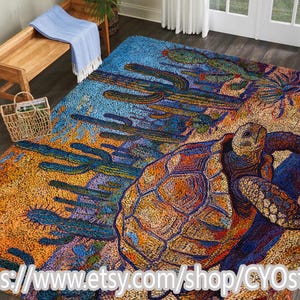 Puede incluir: Una colorida alfombra con una escena desértica con cactus y una tortuga. La alfombra tiene una paleta de colores azul, naranja y verde. La URL de la tienda de Etsy es visible en la parte inferior de la imagen.