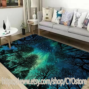 Puede incluir: Una alfombra azul y verde con un diseño de cielo estrellado nocturno y siluetas de árboles. La alfombra está en un salón con un sofá y almohadas.