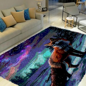 Op de afbeelding: Een kleurrijk tapijt met een vos die op een bergketen staat. Het tapijt heeft een blauw, paars en groen kleurenschema met een sterrenhemel als achtergrond.