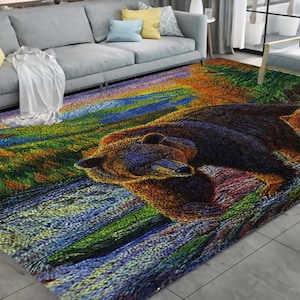 Puede incluir: Una alfombra colorida con un oso marrón caminando por una escena de bosque. La alfombra tiene tonos de verde, azul, amarillo y naranja.