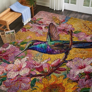 May include: A vibrant area rug featuring a detailed mosaic design of a hummingbird perched on a branch amidst pink and white flowers. The rug has a yellow and orange background, creating a colorful and artistic home decor piece.