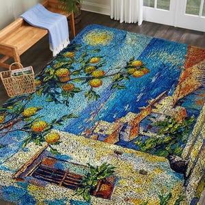 May include: A large, colorful area rug with a mosaic-style design depicting a night scene with a full moon, citrus tree branches, and buildings. The rug features shades of blue, yellow, orange, and white. A wooden bench and basket are in the background.