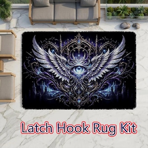 May include: A rectangular latch hook rug kit featuring a central eye motif surrounded by intricate, sprawling silver wings and dark purple and blue gothic architectural patterns against a deep black background with the text Latch Hook Rug Kit.