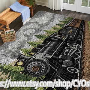 Puede incluir: Una alfombra detallada con un tren de vapor negro con detalles en marrón y dorado, sobre un fondo de árboles verdes y flores amarillas. La alfombra tiene un aspecto texturizado, con un cielo gris y un borde marrón. La URL de la tienda Etsy es visible en la parte inferior.