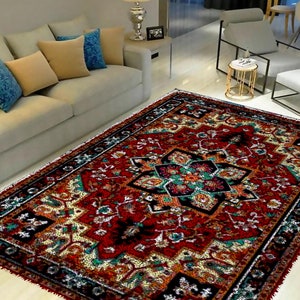 May include: A red, black, and cream colored area rug with a traditional Persian design. The rug has a central medallion with intricate floral patterns and a border with repeating motifs.