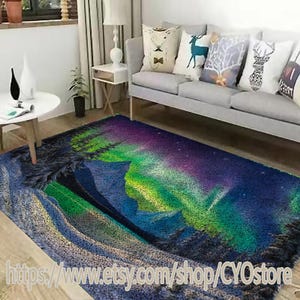 May include: A rectangular area rug featuring a vibrant depiction of the aurora borealis. The rug showcases a blend of blues, greens, and purples, with a textured appearance. The design includes a mountain range and a starry sky.