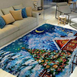 Può includere: Un tappeto rettangolare con una scena invernale con un albero di Natale, una casa e una luna crescente contro un cielo blu. Il tappeto ha un aspetto strutturato e morbido con cuciture dettagliate.