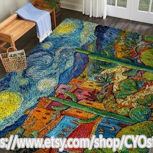 Op de afbeelding: Een kleurrijk vloerkleed met een artistiek ontwerp. Het vloerkleed toont een mix van blauw, geel, oranje en groen, met een patroon dat doet denken aan een sterrennacht en een woestijnlandschap. Het vloerkleed ligt op een houten vloer.