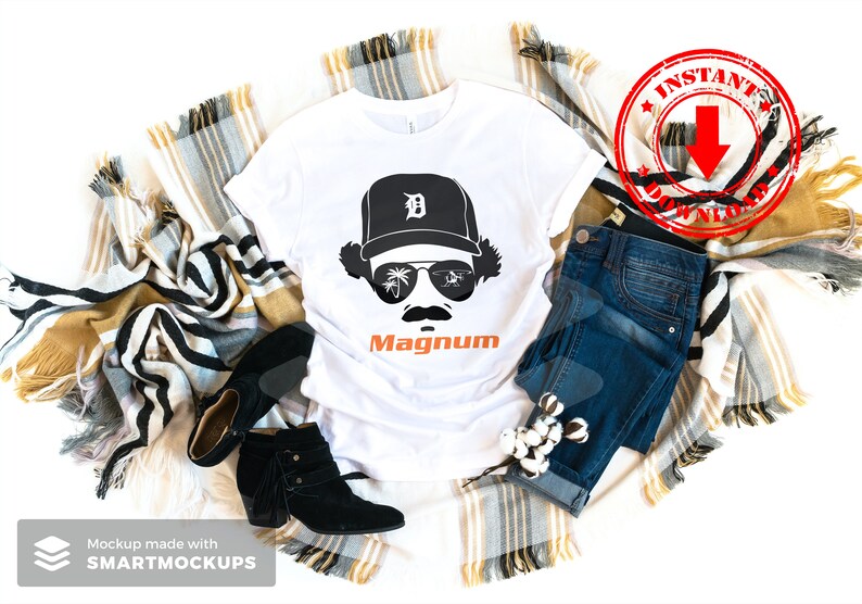 May include: White t-shirt with a black and white illustration of a person wearing a baseball cap with the letter "D" on it and sunglasses. The text "Magnum" is printed in orange below the illustration.