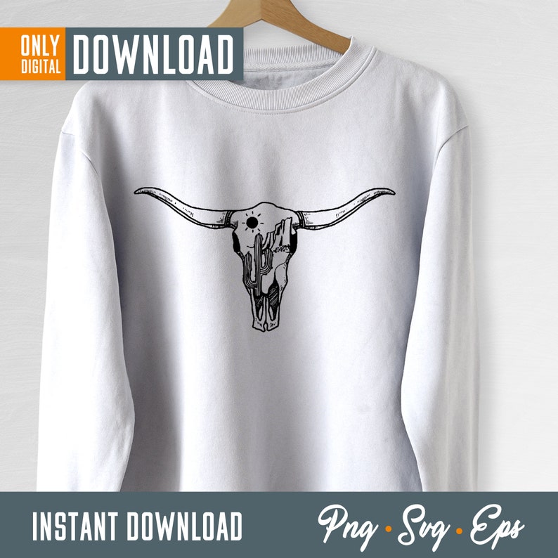 Op de afbeelding: Een wit sweatshirt met een zwart-witte illustratie van een stieren schedel met een cactus en zon erin. De tekst "Download" staat in de rechterbovenhoek van de afbeelding. De tekst "Instant Download" staat in de linkerbenedenhoek van de afbeelding. De tekst "Png - Svg - Eps" staat in de rechterbenedenhoek van de afbeelding.