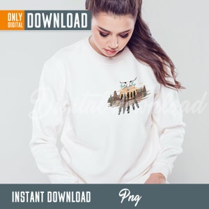 May include: White sweatshirt with a graphic print of a sunset scene with a skull and crossbones, cacti, and silhouettes of people walking. The text "Wild Thing" is above the skull.