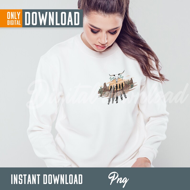 May include: White sweatshirt with a graphic print of a sunset scene with a skull and crossbones, cacti, and silhouettes of people walking. The text "Wild Thing" is above the skull.