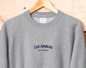May include: A gray sweatshirt with a navy blue embroidered logo that says "Los Angeles, California".