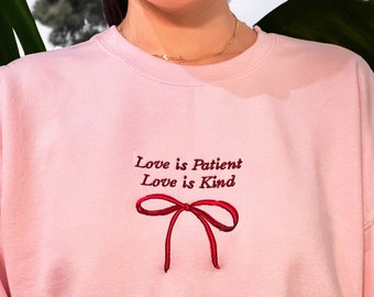 Sweater met geborduurde strik | Liefde is geduldig, ronde hals