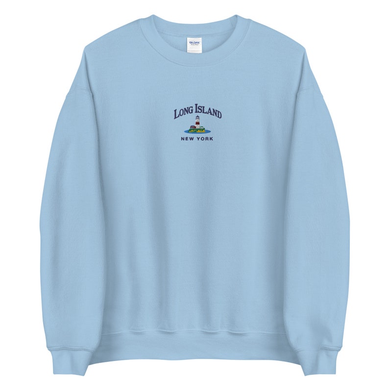 May include: Light blue sweatshirt with an embroidered design of a lighthouse on a small island with the text "Long Island, New York".