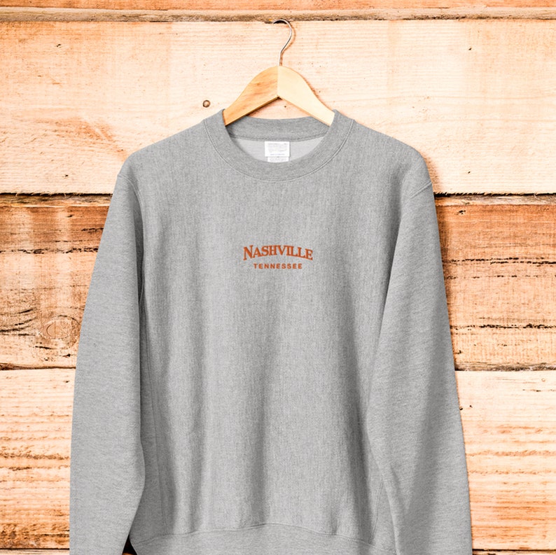 May include: A gray sweatshirt with a brown embroidered logo that says "NASHVILLE TENNESSEE".
