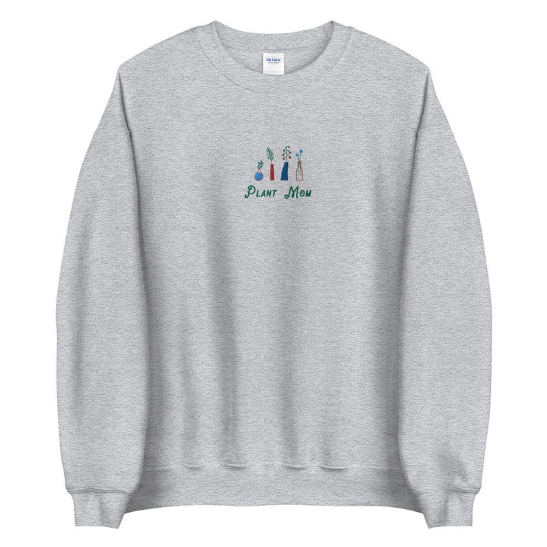 May include: A gray sweatshirt with a green embroidered design of potted plants and the text "PLANT MOM".