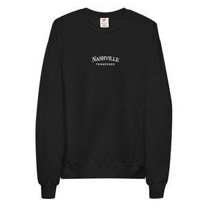May include: Black long-sleeve sweatshirt with a white embroidered design that says "NASHVILLE TENNESSEE".