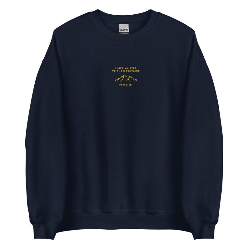 May include: Navy blue sweatshirt with a gold embroidered mountain design and the text "I lift my eyes to the mountains Psalm 121".