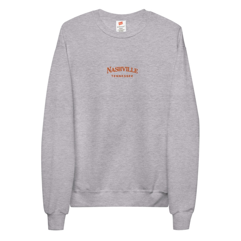 May include: A heather gray sweatshirt with a red embroidered design that says "NASHVILLE TENNESSEE".