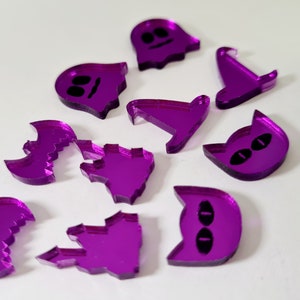 May include: A set of ten purple acrylic Halloween-themed shapes. The shapes include a ghost, a witch's hat, a bat, a cat, and a castle.