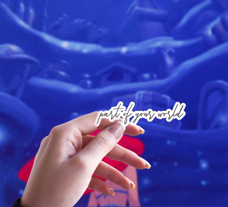May include: A white sticker with the text "part of your world" in a handwritten font. The sticker is held in a hand against a blue background with a cartoonish landscape.