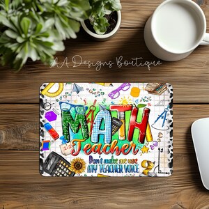 May include: A colorful mousepad with the word "MATH" in large, bold letters. The letters are decorated with various math symbols and patterns. The text "Teacher Don't make me use my teacher voice" is written below the word "MATH".