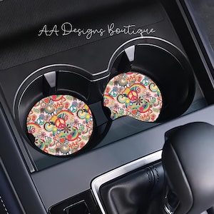 May include: Two colorful car cup coasters with a peace sign and the words "Peace" and "Love" in a retro 1960s style.