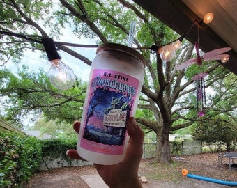May include: A clear plastic tumbler with a pink and black Goosebumps logo featuring the text "R.L. Stine Goosebumps Welcome to Horrorland".