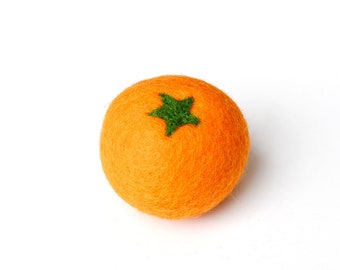Può includere: Un'arancia di feltro con una foglia verde a forma di stella in cima. L'arancia è di colore arancione brillante e la foglia è di colore verde brillante.