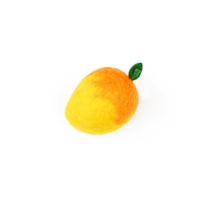 May include: A felt mango with a green leaf, a yellow and orange fruit with a smooth texture.