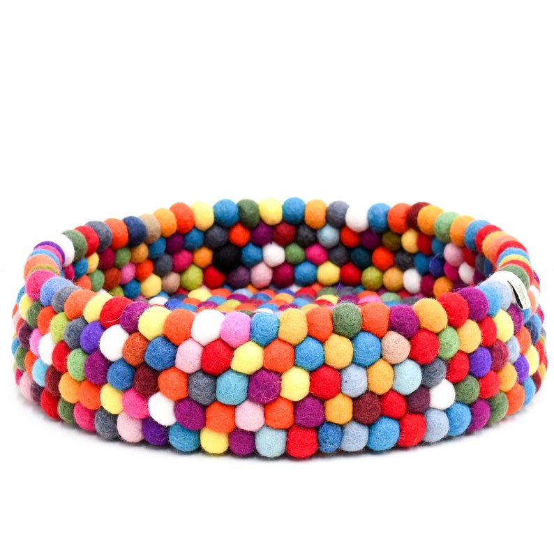 May include: A round pet bed made of colorful felt balls. The bed features a vibrant mix of red, orange, yellow, green, blue, purple, and white balls, creating a textured and visually appealing design. The bed is designed for small pets.