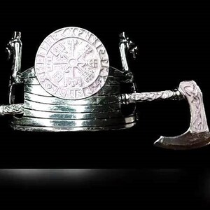 May include: A silver Viking ship with a silver axe and a silver sword. The ship has a round silver shield with a Viking symbol on it.