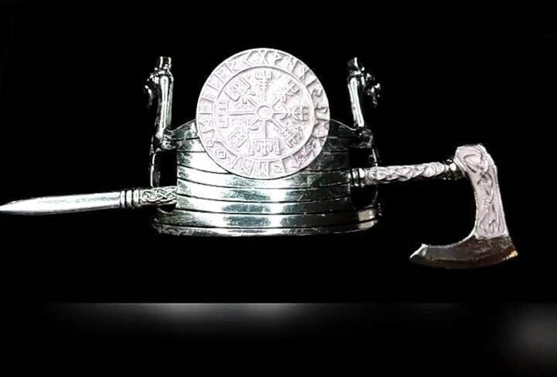May include: A silver Viking ship with a silver axe and a silver sword. The ship has a round silver shield with a Viking symbol on it.