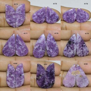 Pode incluir: Um conjunto de 10 pares de cabochões de lepidolita roxa e branca, cada par é etiquetado com um número de 4174 a 4183.