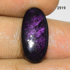 Puede incluir: Una piedra preciosa ovalada de color p&uacute;rpura oscuro con brillo iridiscente. La piedra preciosa est&aacute; engastada en un anillo de plata.